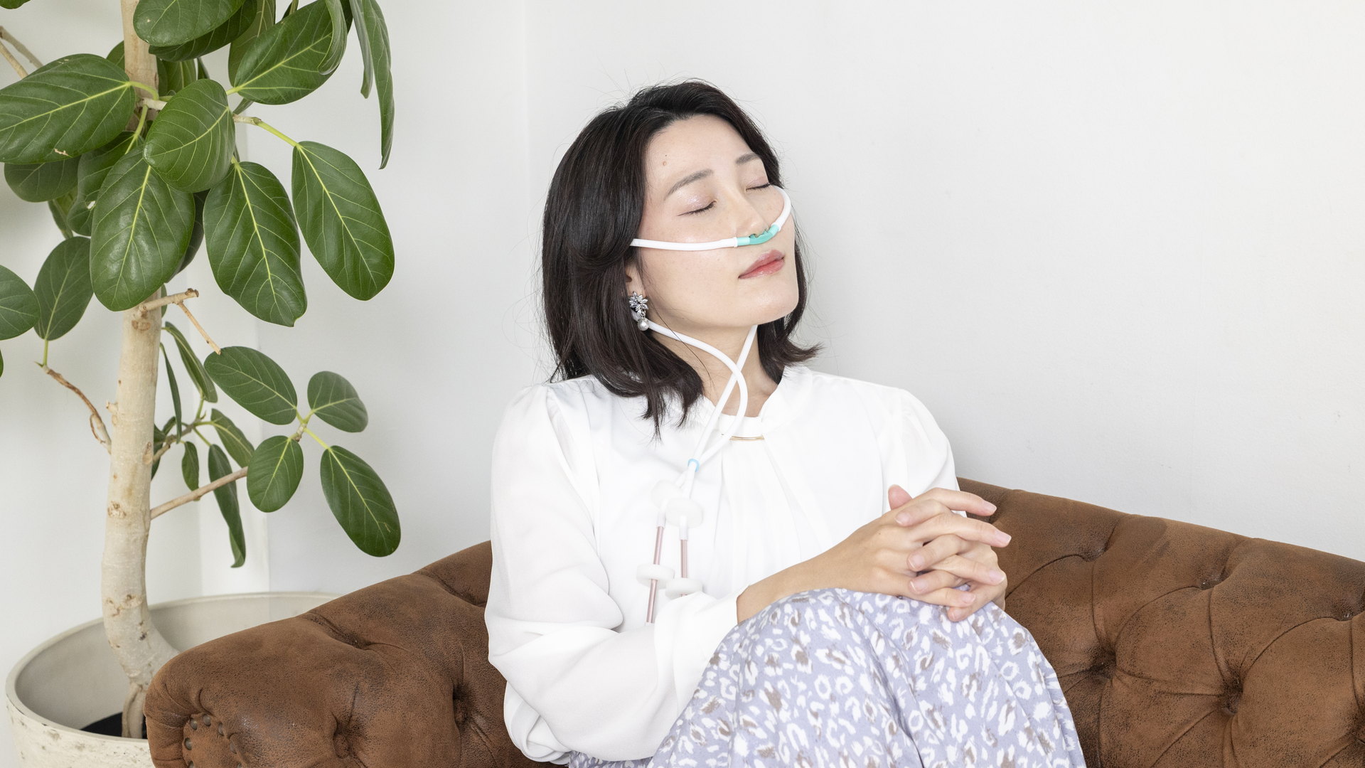 鼻カニューラを着けて穏やかに目を閉じ、水素を吸入する女性